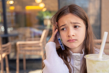 Sad girl talking on the phone. A girl with a phone.