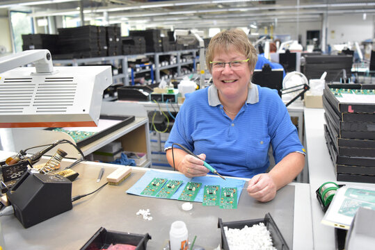 friendly woman working in a microelectronics manufacturing factory - component assembly and soldering