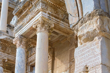 Fototapeta premium Ancient architectural details of Celsus library in Ephesus, engraved text of emperor Trajan glorifying at Ancient Greek language, monument of epigraphy. Selcuk, Turkey (Turkiye)