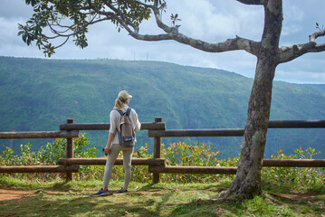 Woman is enjoying a gorgeous view of an ancient tropical mountain forest in Mauritius