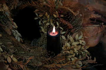 burning black candle in autumnal leaves, abstract dark nature background. mysterious fairy scene....