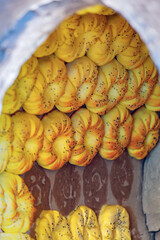 Traditional Uzbek bread baking in a tandoor oven, showcasing a golden, freshly baked texture with sesame seeds, arranged in a circular pattern. Tashkent, Uzbekistan