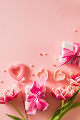 Pink tulips and hearts, gift box with ribbon on light pink background