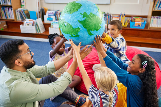 Happy multiethnic children holding planet earth globe at school