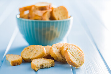 Sliced roasted bruschetta bread on blue table.