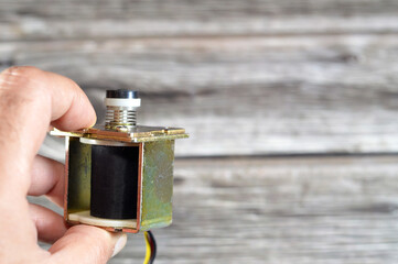 Gas geyser coil solenoid valve of gas water heater, maintenance and repairing home appliances concept, a solenoid valve is an electromechanically operated valve that opens for the gas to pass