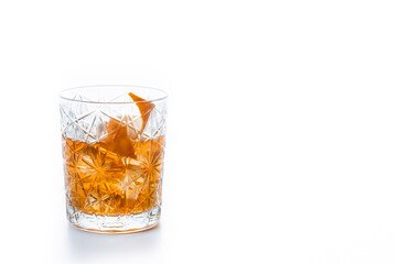 Old fashioned cocktail garnished with orange isolated on white background. Copy space