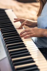 Female hands on the piano. The girl plays the piano. Musical instrument.