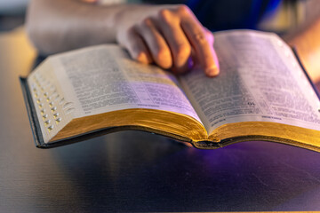 A man reads the Bible. Male hands on the Holy Bible. Close-up of the Bible.