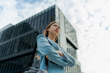 Obraz premium Portrait of a young and confident businesswoman standing in front a modern office building in the financial district
