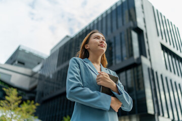 Fototapeta premium Young Businesswoman Using Digital Tablet In Front A Modern Office Building in a Financial District