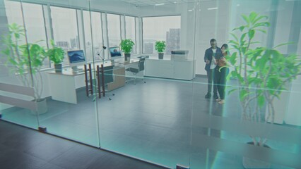 Multiethnic team of two designers using app on tablet computer to design interior in office room with 3D furniture and digital equipment in virtual space. Futuristic VFX animation. Augmented reality.