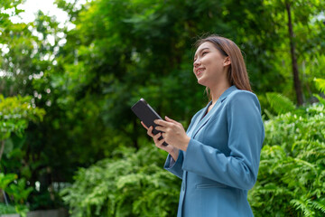 Asian Businesswoman Using Digital Tablet Amid Greenery in A Park