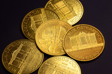 Photography close up of real golden coins on a black table and black background, photo of business, investors and market of gold growing up. with the collection of philharmonic of Austria.