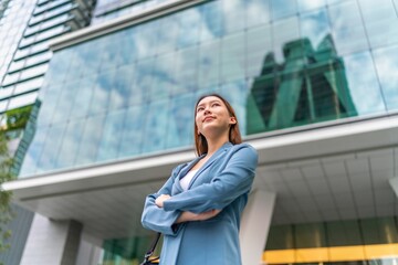 Confident Young Businesswoman With Laptop Bag In Front a Modern Office Building in a Financial Business District