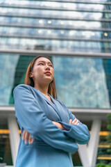 Portrait of a young and confident businesswoman standing in front a modern office building in a financial district