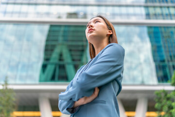 Portrait of a young and confident businesswoman standing in front a modern office building in a financial district