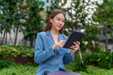 Young Asian Businesswoman Using Digital Tablet Outdoor In Front Modern Office Building