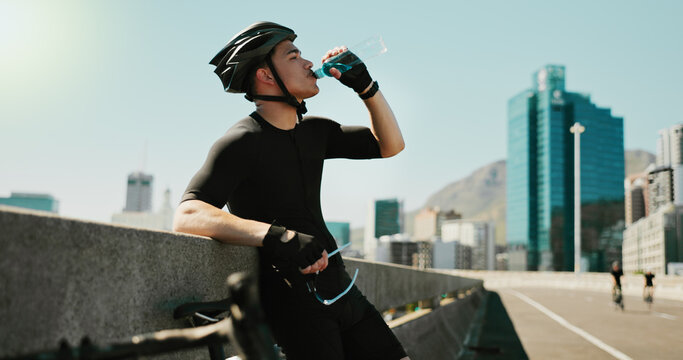 Drinking water, training and cycling with man in city for triathlon challenge, electrolytes and workout. Wellness, exercise and competition with person and bike for sports, fitness and cardio