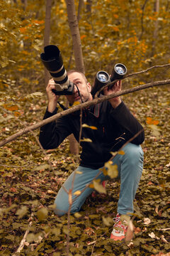 Man using binoculars and camera for birdwatching and other observable animals in nature.