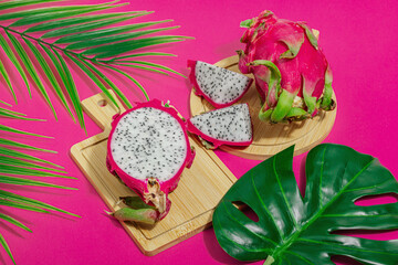 Fresh pitahaya on bright pink background. Dragon fruit harvest, tropical product