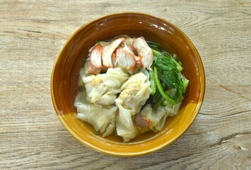Chinese dumpling topping slice red barbecue pork with clear soup on bowl