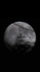 Close-up view of the full moon with dramatic shadows in a dark night sky