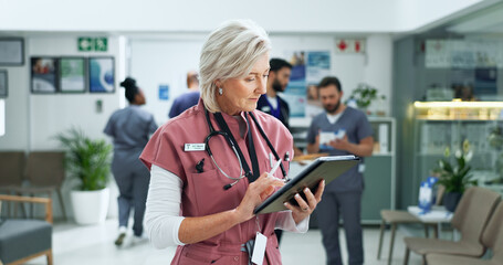 Obraz premium Tablet, telehealth and mature woman doctor in hospital with medical research or feedback. Digital technology, reading and female healthcare worker with online surgery or treatment plan in clinic.