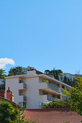 Modern apartment building in Marseille with a clear blue sky and surrounding vegetation. The building features balconies and a contemporary design, making it for themes related to urban architecture.