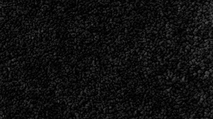 Fototapeta premium Close-up of dense black carpet fibers with a textured surface, providing a soft, luxurious feel and deep, rich color for modern interiors