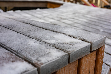 Stairs, wooden boards, wooden slats covered in snow, creating a textured surface. Early snow, Boards in frost. A wooden deck covered in frost, copy space.