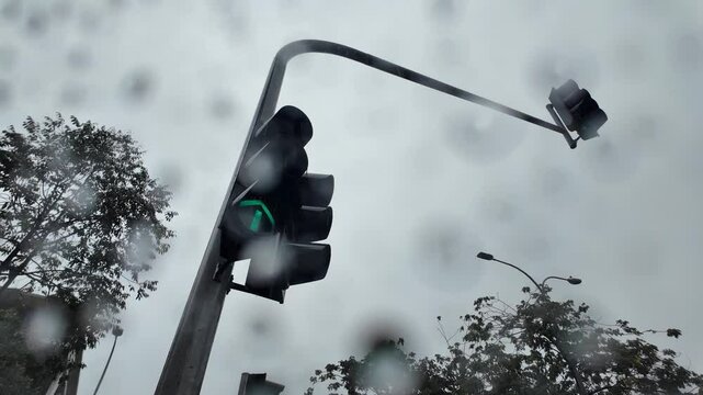 Panning shot of traffic light through a window during rain LTR
