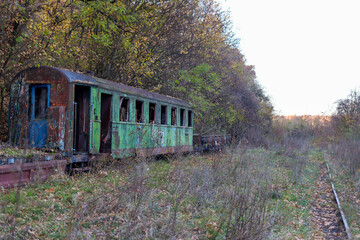Fototapeta premium Abandoned diesel locomotive with cars.old , rusty train stands in an abandoned station. High quality photo