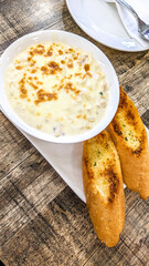 Top view of a bowl of mac and cheese served in a round bowl with 2 pieces of crunchy garlic breads