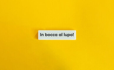 In bocca al lupo. Italian Idiom and Text on Block Letter Tile on Yellow Background. Minimal Aesthetic.