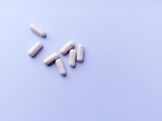 Obraz premium Creatine capsules on bright paper background. Soft focus. Close up. Copy space. 
