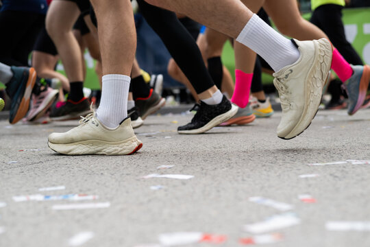 Closeup long exposure many persons and legs running marathon race stock photo with space for text non recognizable people on it