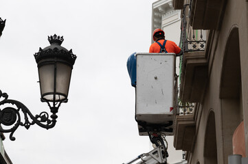 Trabajo en altura con cesta de un operario en un edificio.
