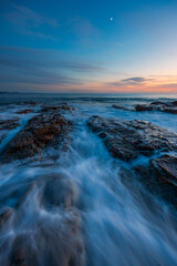 Serene view of the rocky shore at dawn.