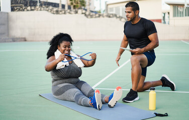 African curvy woman and personal trainer doing sport fitness workout session outdoor - Fit activity...