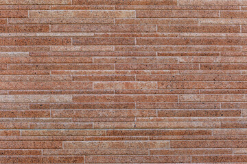 Wall of narrow beige tiles. Construction and repair. Background. Space for text.