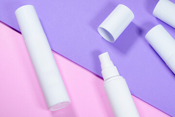 White spray bottles arranged on pink and purple background, clean and minimalist aesthetic mockup