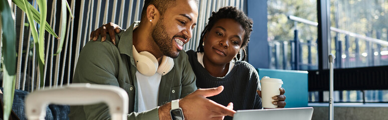 A young couple joyfully discusses their travel plans while enjoying a moment in the hotel lobby. © LIGHTFIELD STUDIOS