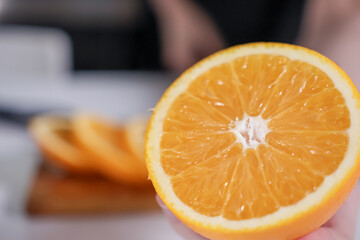 Closeup of a juicy orange half, vibrant and fresh, with sliced fruit in background