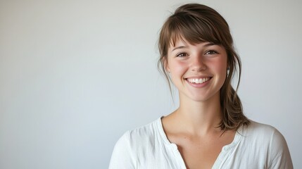 Obraz premium Smiling young Caucasian woman with a friendly expression on a plain background, allowing copy space for text or branding.