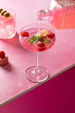 Elegant pink gin cocktail with lemon and mint garnish