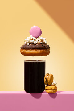 Colorful dessert stack with coffee, donut, popcorn, and macarons