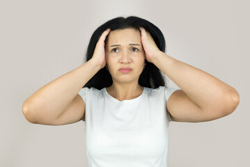 confused woman holding her head with her hands