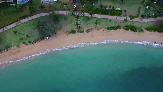 Aerial view of tropical Hawaiian beach with turquoise blue water. Incredibly Beautiful Kapaa Beach Park with turquoise blue water and sandy beach. Top down View of kappa beach in Kauai Hawaii.