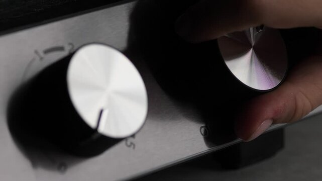 close up of female hand turning round switch to off position on electric oven, mode switch or timer on electric kitchen stove, woman finished cooking food